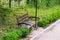 An empty bench in the morning park, amid a treadmill and trees