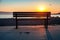 Empty bench on a sea coast with shining morning sun