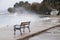 Empty benches by the stormy sea splashed by the waves