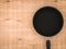 Empty black pan on wooden table