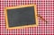 Empty blackboard with chalk on a checkered table cloth