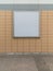 Empty blank square white advertising billboard on orange tiled wall
