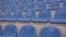 Empty bleacher in sports stadium. Blue seats in street stadium. Close up.