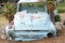 Empty blue car as garden decoration in Namibia, rusty abandoned car in sand dunes of Namibia