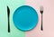 Empty blue plate fork and knife on duotone green pink background. Healthy diet meal planning concept. Mockup template