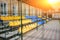 Empty blue and yellow sports seats of the grand stand at the back yard of school on the stadium