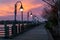 Empty boardwalk illuminated by lanterns during beautiful sunset in Wilmington, North Carolina
