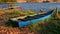 Empty Boat Bound on Grass Bank at Wooden Pier by Lake