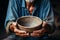 Empty bowl in aged hands, selective focus emphasizes hunger and the elderlys plight