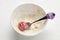 Empty bowl with oatmeal leftovers and a child spoon with strawberries on a white background