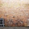 Empty brick wall for mockup with a bike and decor on a urban exterior.