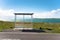 Empty bus stop along a coast road and blue sky