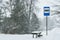 Empty bus stop on a winter road in a blizzard