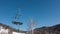 An empty cabin of a chairlift on a cable