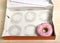 Empty cakes box with only one tempting and delicious donut with toppings left