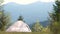 Empty camping tent standing on campsite with view of majestic high mountain peaks in distance. Hiking in wild nature and active tr