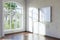 empty canvas poster mock up hanging on a wall empty living room interior bright daylight shining through a large window home