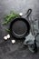 Empty cast iron frying pan on dark grey culinary background, view from above