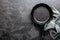 Empty cast iron frying pan on dark grey culinary background, view from above