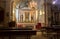 Empty catholic cathedral. Church altar with chandelier, saint sculptures and benches. Church interior with altar.