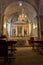 Empty catholic cathedral. Church altar with chandelier, saint sculptures and benches. Church interior with altar.