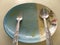 Empty ceramic dish with chicken tracery on the dish spoon and fork on top view. After meal