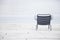 Empty chair on the beach in cloudy weather. Concept of loneliness, depression, emptiness and solitude