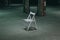 An empty chair in a dark room. A lonely object standing in empty concrete walls at dusk, a symbolism of loneliness of fear,