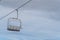 Empty chair lift covered with snow against sky