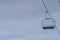 Empty chair lift with icicles against cloudy sky