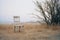 an empty chair sits in the middle of a field