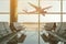 Empty chairs in the departure hall at airport on background of airplane taking off at sunset. Travel concept