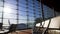 Empty chairs in sunlit airport terminal, plane standing behind window, boarding