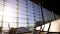 Empty chairs in sunlit airport terminal, plane standing behind window, boarding