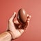 Empty Chocolate Egg In Hand On Red Background