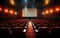 Empty cinema theater with red seats, curtains and a blank white screen ready for the audience to enjoy a movie