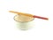 Empty circle beige ceramic bowl with brown rim and white small pattern, chopsticks isolated on a white background.