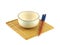 Empty circle beige ceramic bowl with brown rim and white small pattern, chopsticks over bamboo mat isolated on a white background.