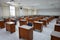 Empty classroom with vintage tone wooden chairs. Classroom arrangement in social distancing concept to prevent COVID-19 pandemic.