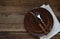 Empty clay plate, cutlery, napkin on wooden background. Table setting captured from above. Top view, flat lay. Rustic style. Copy