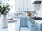 Empty and clean marble dining table in scandinavian kitchen. Modern monochrome interior with blue drawers on wooden