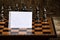 Empty Clean Spiral Bound Ruled Notebook Sheet Torn Off and Folded in Half Placed on Chessboard in Front of Black Themed