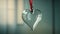 Empty clear glass heart hanging on a ribbon