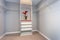 Empty closet interior with shelves and white cabinet.