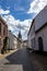 Empty cobbled street between house with white walls, tower of St. Michael\\\'s Abbey church in background