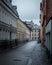 An empty cobblestoned street bordered with old colorful houses on a rainy day in MalmÃ¶, Sweden