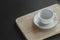 Empty coffee cups on coasters Placed on a wooden plate in a black background