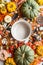 Empty coking pan with wooden spoon on table with many various colorful pumpkins and other autumn ingredients: nuts and spices. Top