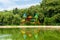 Empty colorful children playground castle with green lush vegetation background and water lake reflection in the foreground situat