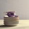 Empty colorful porcelain tableware. Violet cup with plates on lilac background. Toned